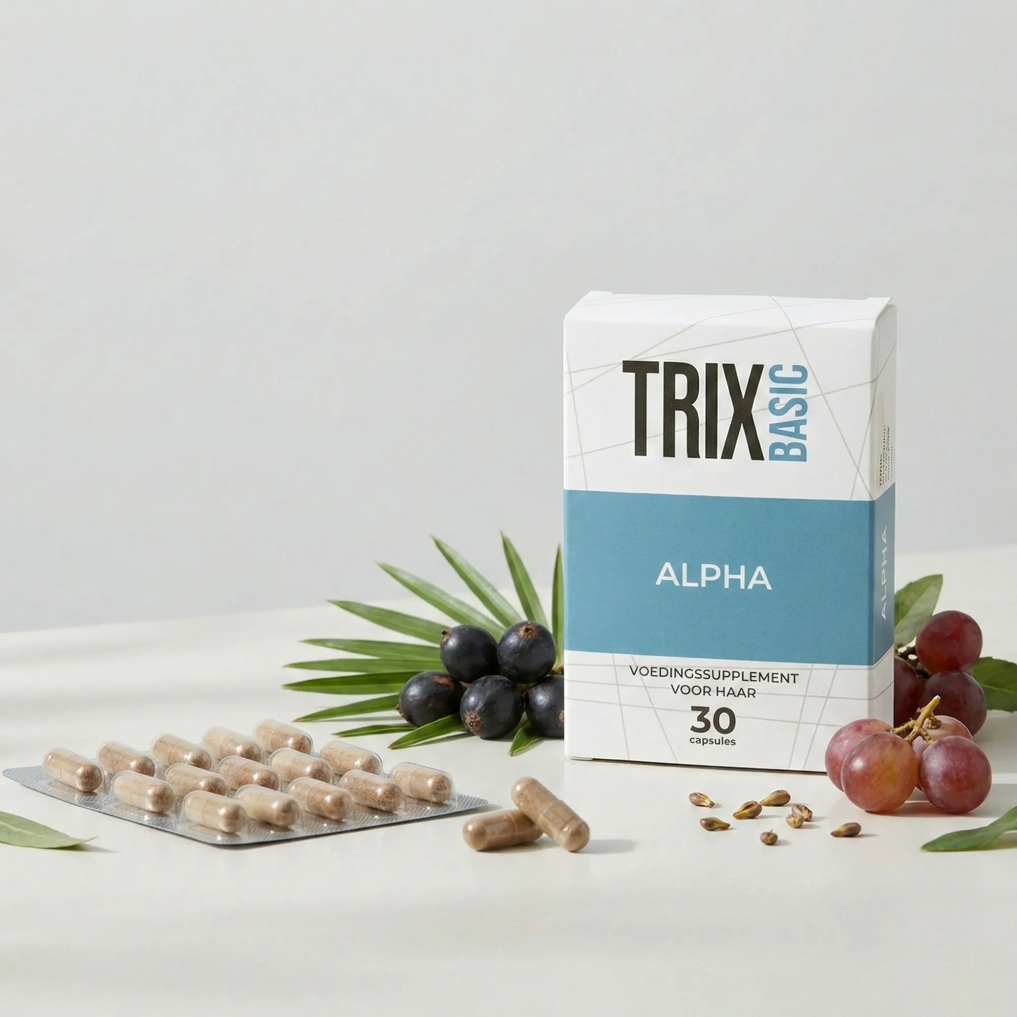 TRIX Basic Alpha voedingssupplement voor haar in verpakking met capsules in blister, saw palmetto bessen en druiven op witte achtergrond.