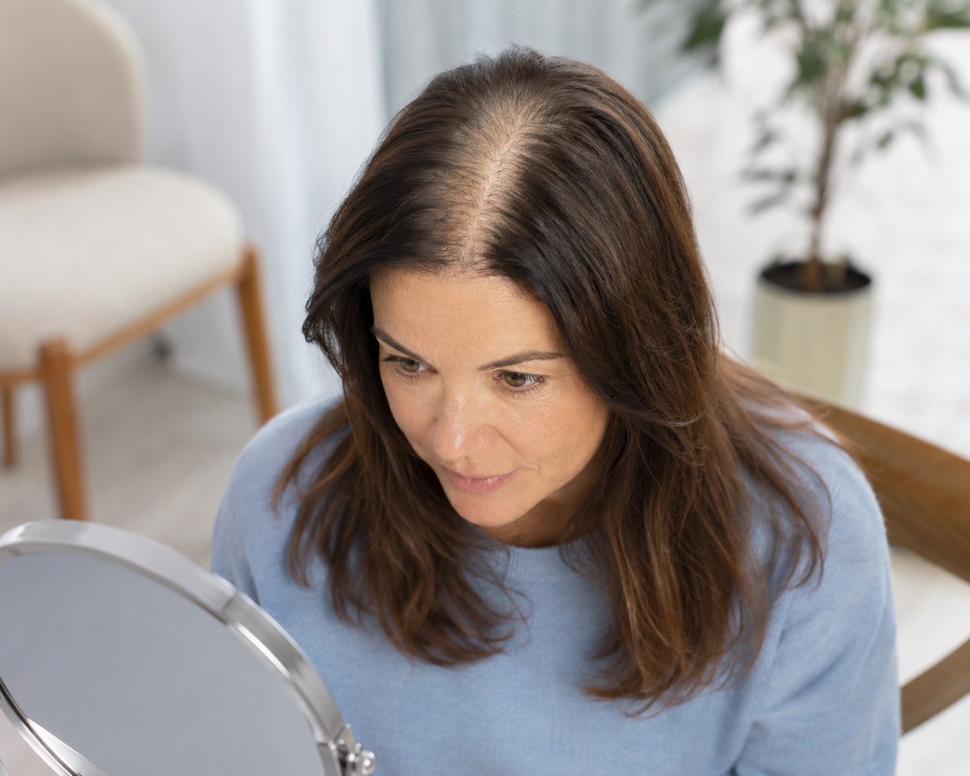 Bovenaanzicht van een vrouw met een geleidelijk bredere middenscheiding.